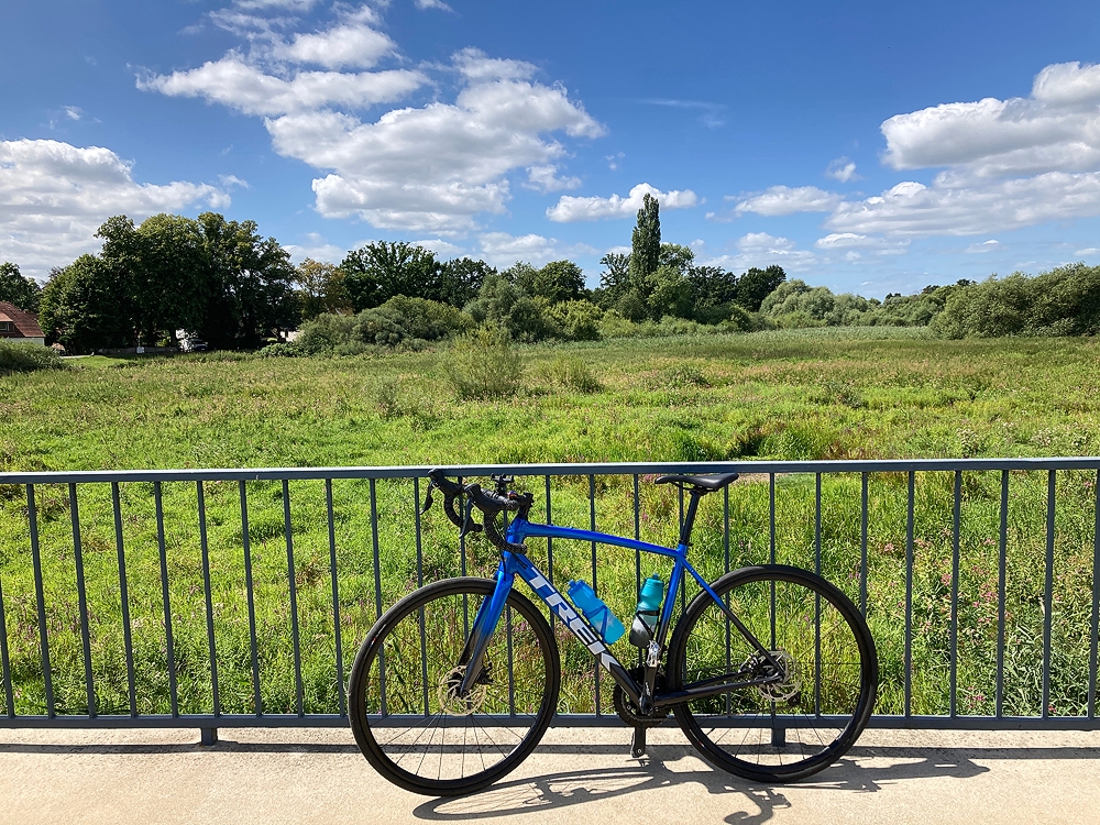 Mein Rad auf der verbindenden Brücke mit Blick auf eine wilde Wiese