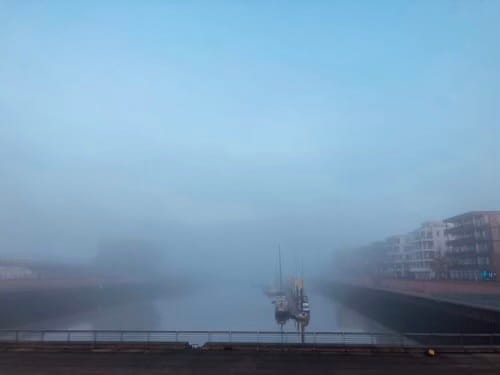 a foggy port with faintly visible