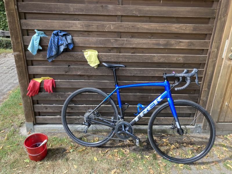 my bike leaning against the bicycle shed with several cleaning utensils around